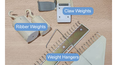 A flat lay arrangement of various machine knitting weights, showing different sizes and styles of claw weights and ribber weights used for tension control