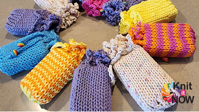 Collection of colorful knitted soap sacks displayed together, showcasing different patterns and yarns used in this charity knitting project