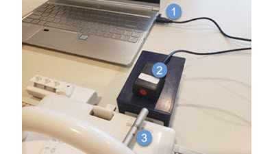 DesignaKnit software interface connected to a non-electronic knitting machine via specialized cables, showing how manual machines can be integrated with digital knitting software