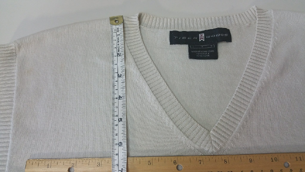 Use a straight edge to measure from the bottom most point of the neck opening to the shoulder seam. This sample is 6.5".