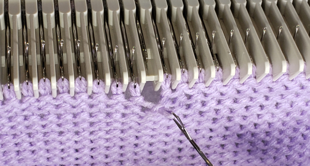 Continue to pull back, pulling the strand through the stitch, forming a new stitch