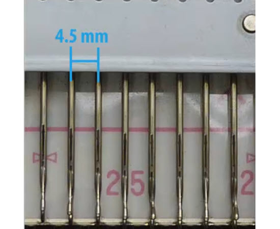 Close-up of knitting machine needle spacing