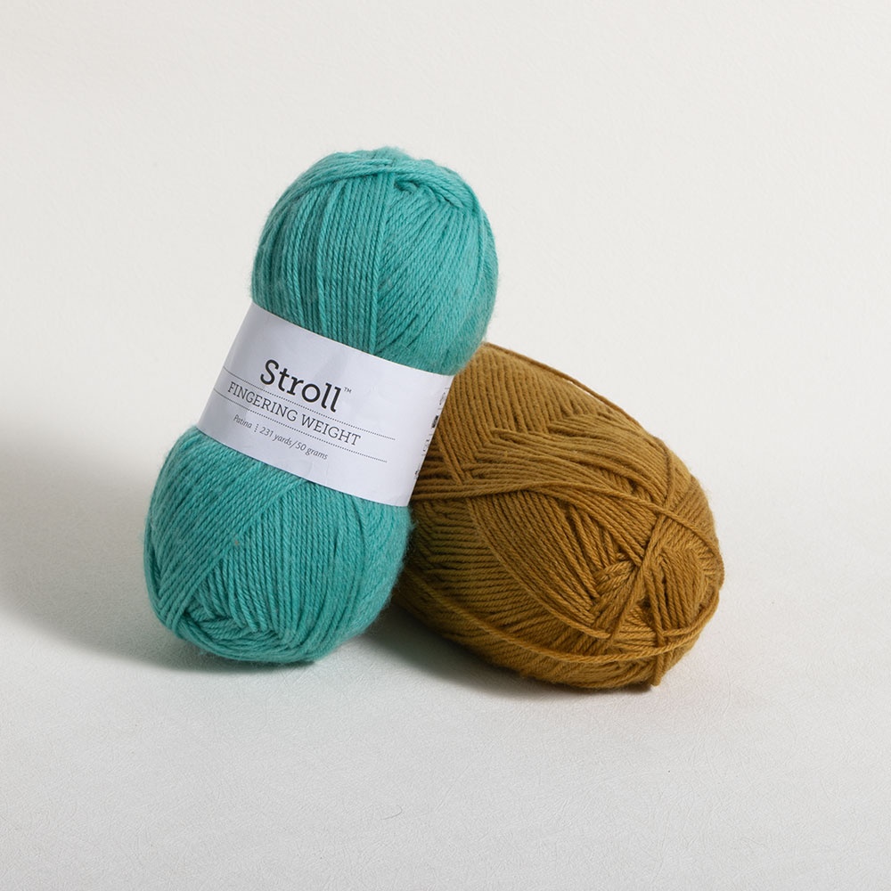 Two balls of Knit Picks Stroll fingering-weight yarn, one turquoise and one mustard gold.