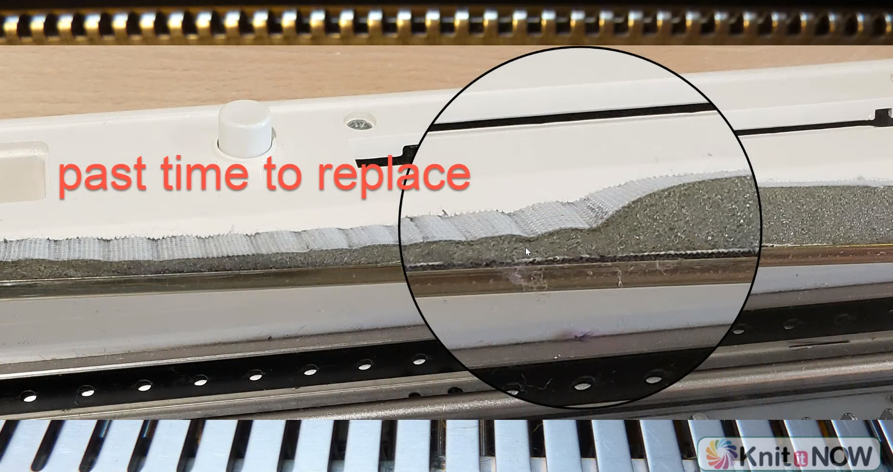 A worn sponge bar on a metal-bed knitting machine, marked past time to replace. The sponge is crumbling and compressed, so it no longer holds the needles evenly.